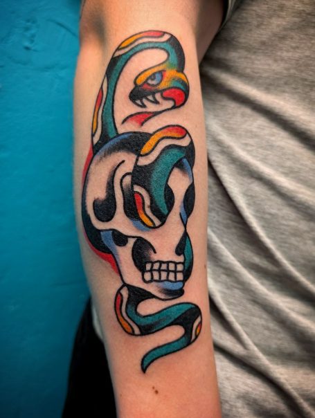 traditional tattoo berlin - tattoos by mariano - Buntes Tattoo eines Schädels mit einer Schlange in lebhaften Farben.