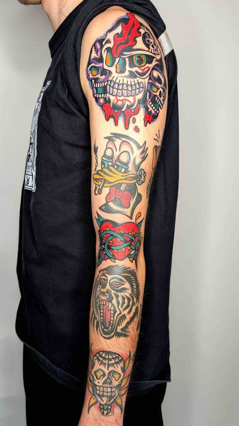 Traditional Tattoo Berlin - Tattoos by Mariano - Colorful traditional tattoo arm sleeve with various motifs, next to a patterned background.