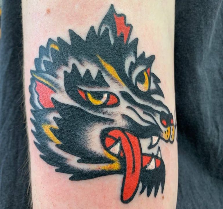 Traditional tattoo Berlin - Tattoos by Mariano - Tattoo of a wolf's head with a red mouth and yellow eyes.