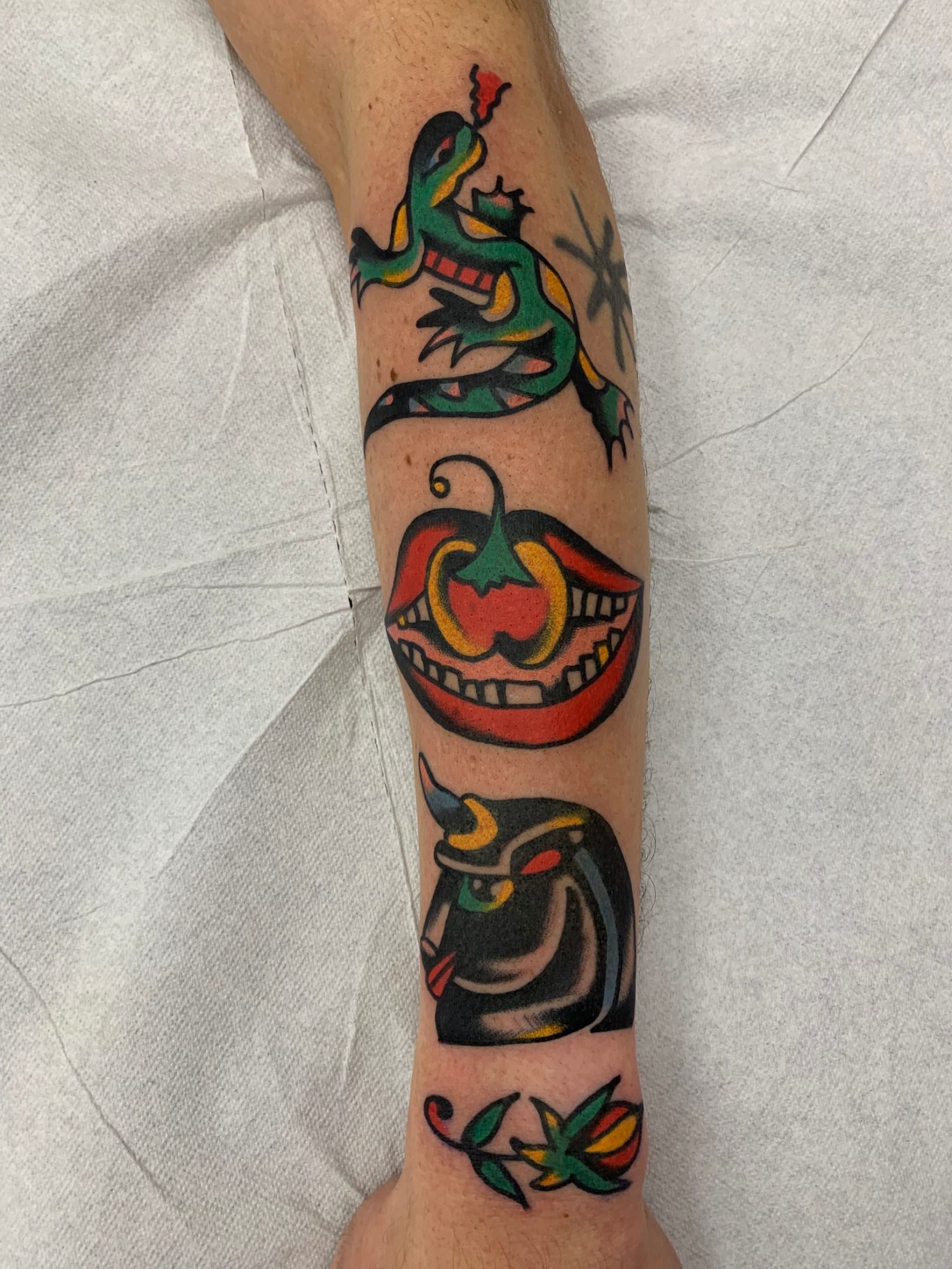 FOREARM STACK Traditional Tattoo Berlin - Tattoos by Mariano - Bunter Arm-Tattoo mit Eidechse, Lippen, Paprika und stilisierten Mustern.