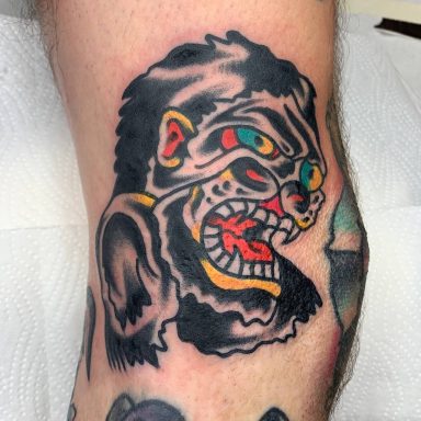 traditional tattoo artists in Berlin - Tattoos by Mariano - Tattoo eines aggressiv blickenden Affenkopfes mit bunten Akzenten.