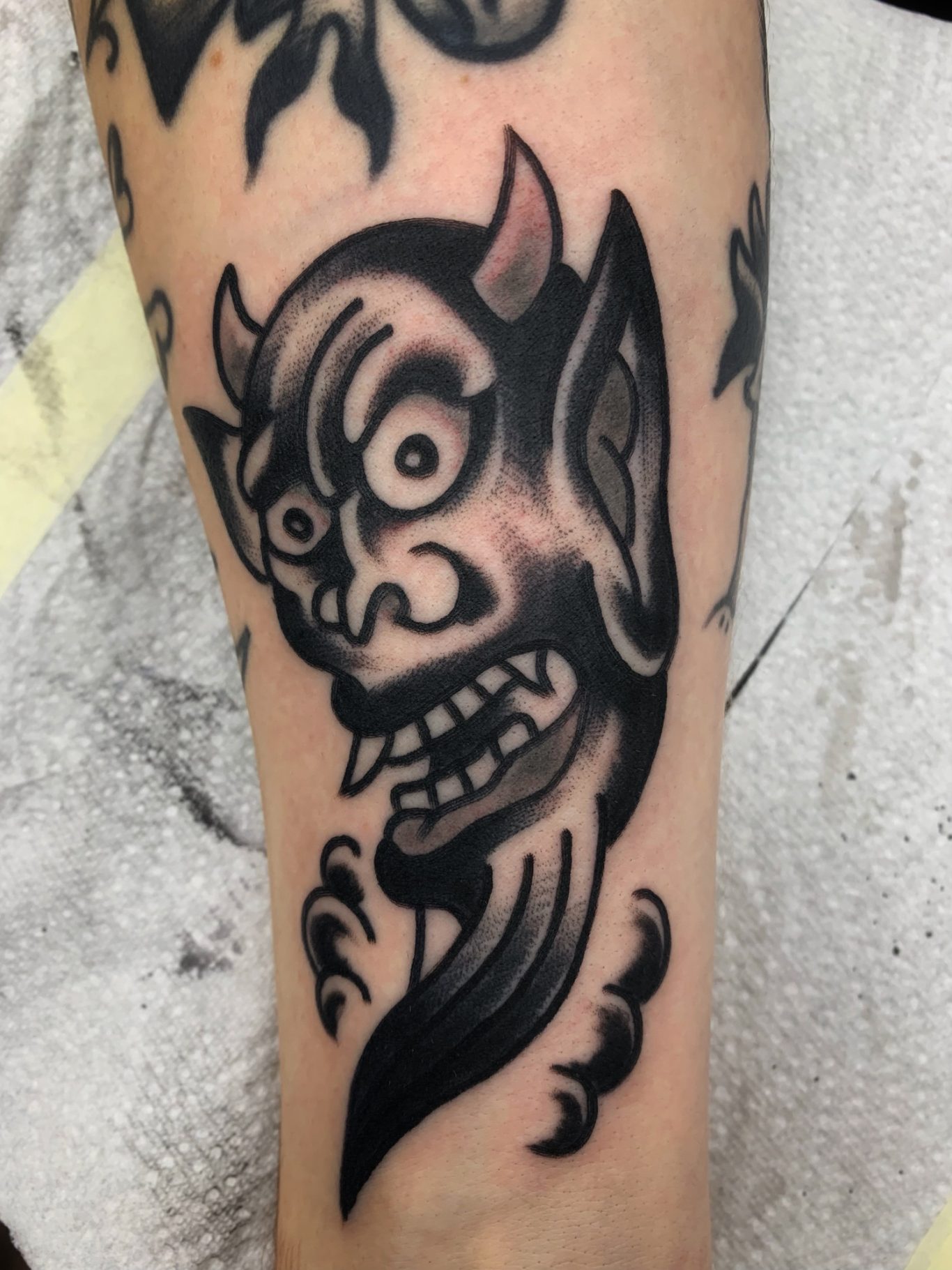 DEVIL Traditional Tattoo Berlin - Tattoos by Mariano - Teufelskopf-Tattoo mit großen Augen, spitzen Ohren und verzerrtem Gesichtsausdruck.