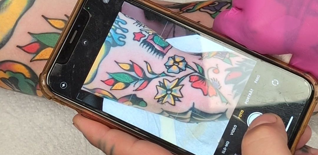 Traditional Tattoo Berlin - Tattoos by Mariano - Close-up of a colorful tattoo on the arm, photographed with a smartphone.