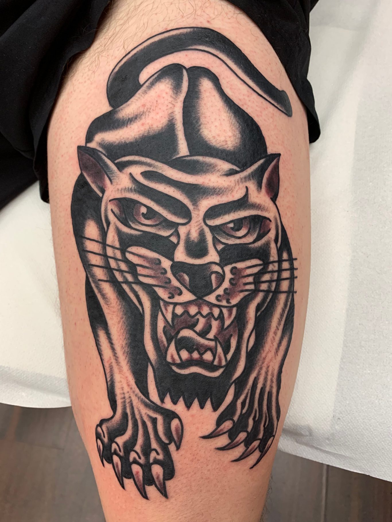 PANTHER Traditional Tattoo Berlin - Tattoos by Mariano - Tattoo eines aggressiven Panthers auf dem Oberschenkel, in Schwarz-Weiß gehalten.