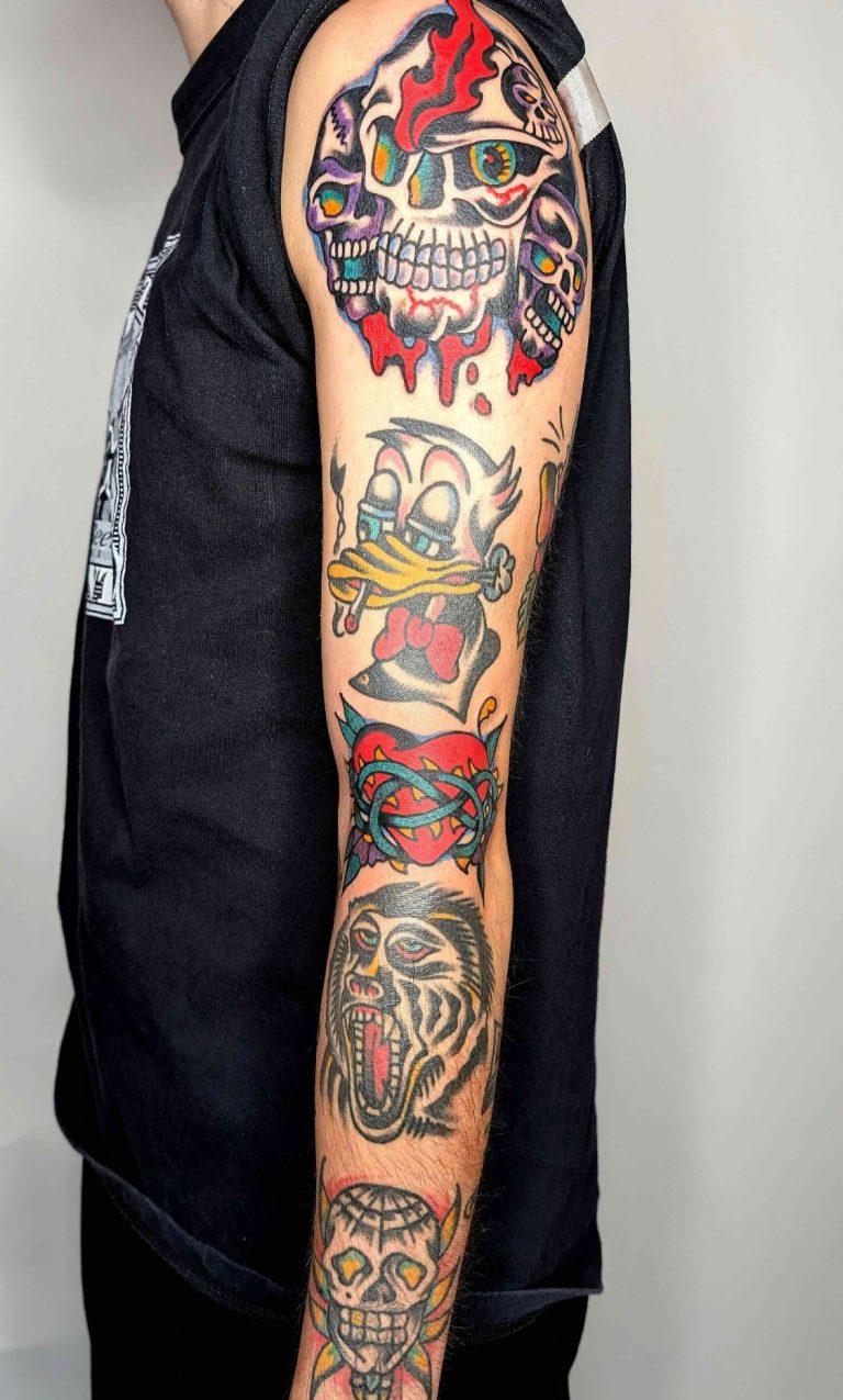 Traditional tattoo Berlin – Tattoos by Mariano – Colorful dragon tattoo on a person's back, with dynamic details.