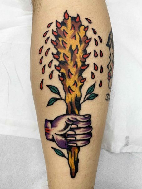 Tattoo eines Hände, die einen brennenden Stock mit Tropfen und Blättern halten.